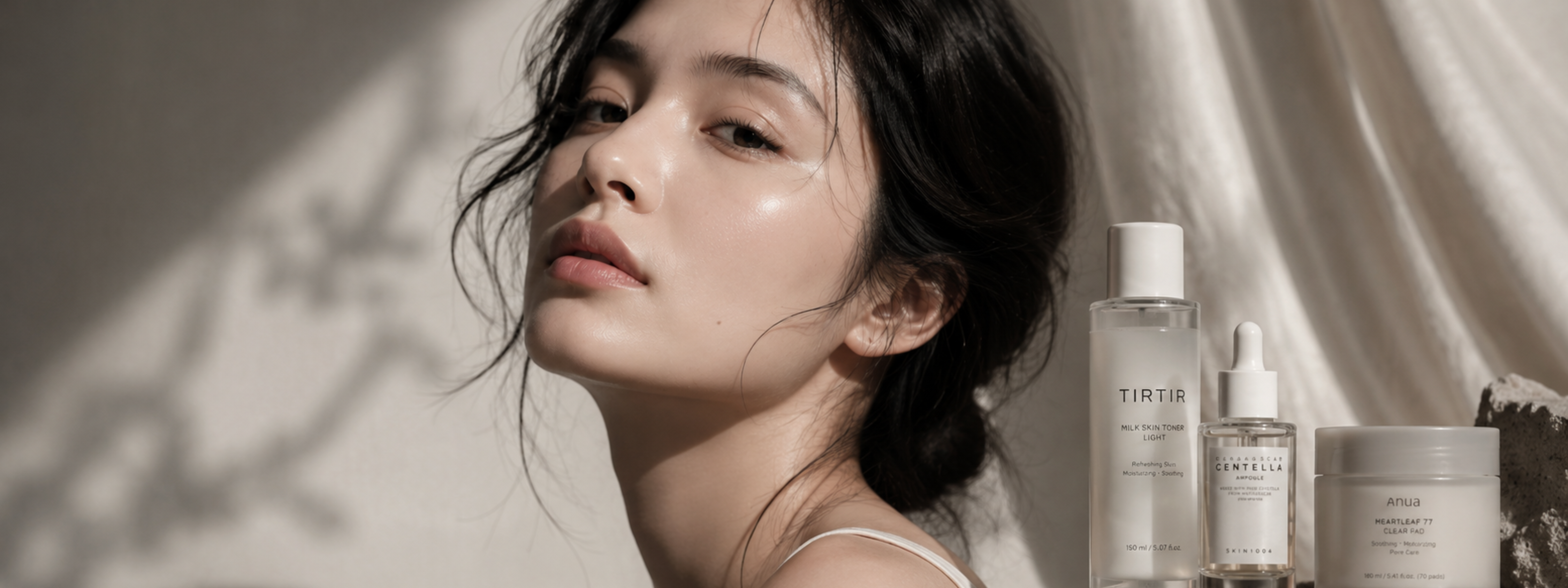 Woman with a Korean skincare product lineup on a neutral background