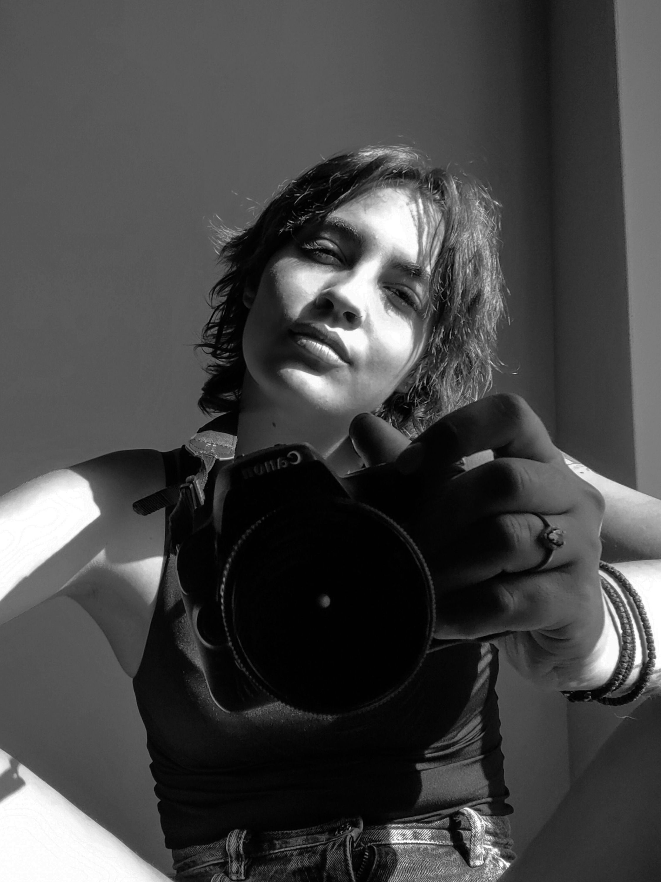 Person holding a camera with a neutral background